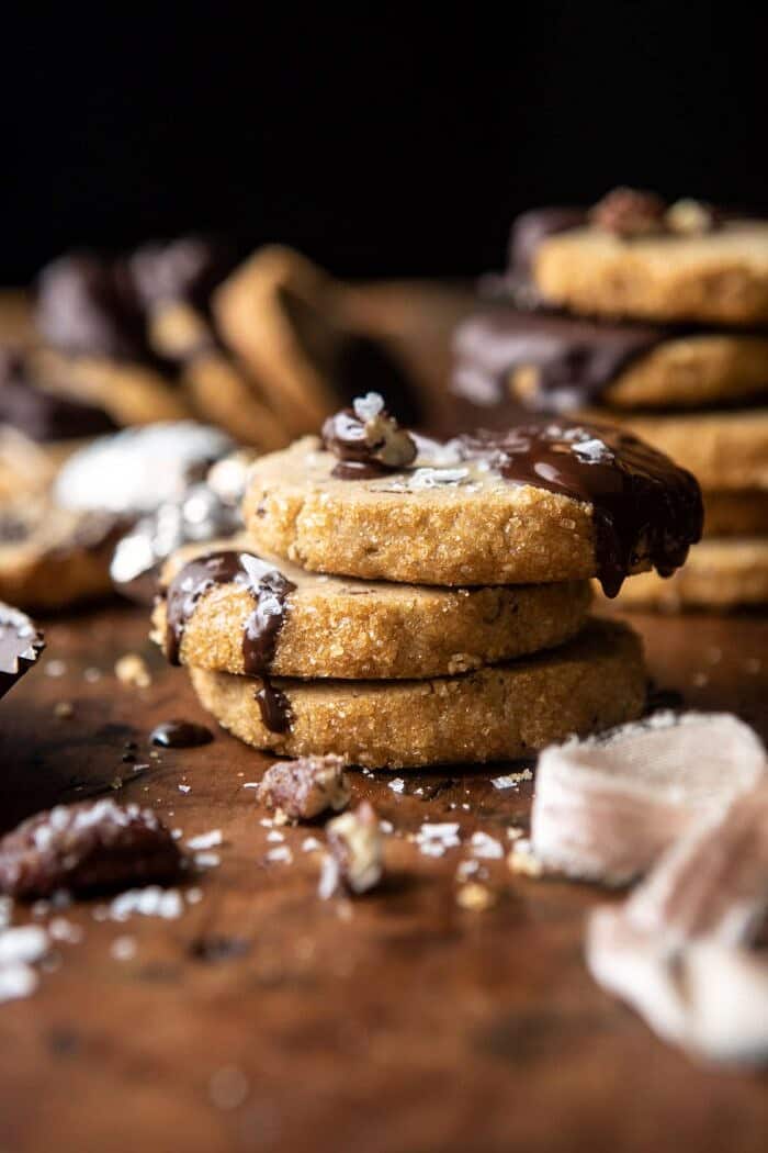 Slice n Bake Salted Chocolate Butter Pecan Cookies | halfbakedharvest.com #cookies #christmas #thanksgiving #chocolate close up side angle photo of Slice n Bake Salted Chocolate Butter Pecan Cookies with 3 cookies stacked together