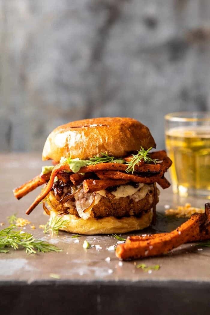 Crispy Quinoa Burgers Topped with Sweet Potato Fries and Beer Caramelized Onions | halfbakedharvest.com #quinoaburger side angle photo of Crispy Quinoa Burgers Topped with Sweet Potato Fries and Beer Caramelized Onions