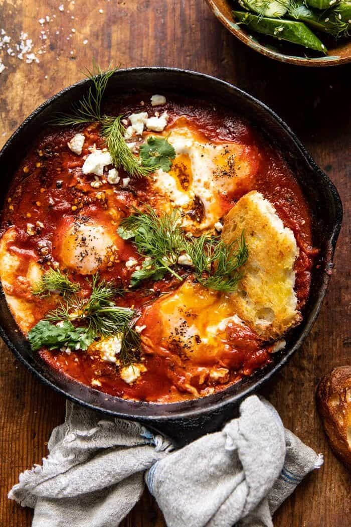 Eggs in Purgatory with Chile Butter and Feta | halfbakedharvest.com #breakfastrecipe #eggs overhead photo of Eggs in Purgatory with Chile Butter and Feta and toast in eggs to break the yolk