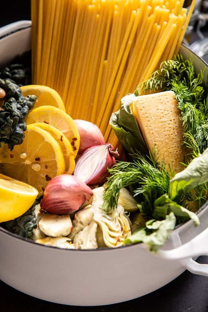 One Pot Creamy Tuscan Pesto and Artichoke Pasta | halfbakedharvest.com #onepot #pasta side angled photo of One Pot Creamy Tuscan Pesto and Artichoke Pasta before cooking