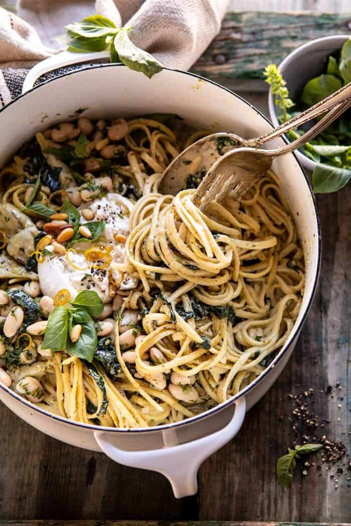 One Pot Creamy Tuscan Pesto and Artichoke Pasta | halfbakedharvest.com #onepot #pasta overhead close up photo of One Pot Creamy Tuscan Pesto and Artichoke Pasta