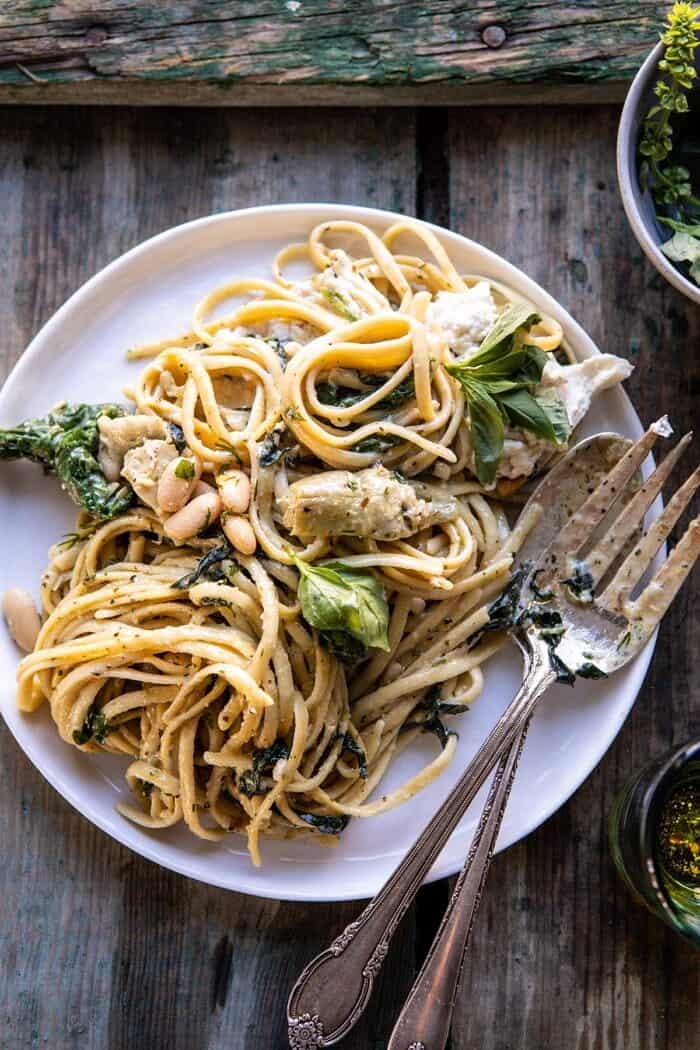 One Pot Creamy Tuscan Pesto and Artichoke Pasta | halfbakedharvest.com #onepot #pasta overhead photo of One Pot Creamy Tuscan Pesto and Artichoke Pasta on serving plate