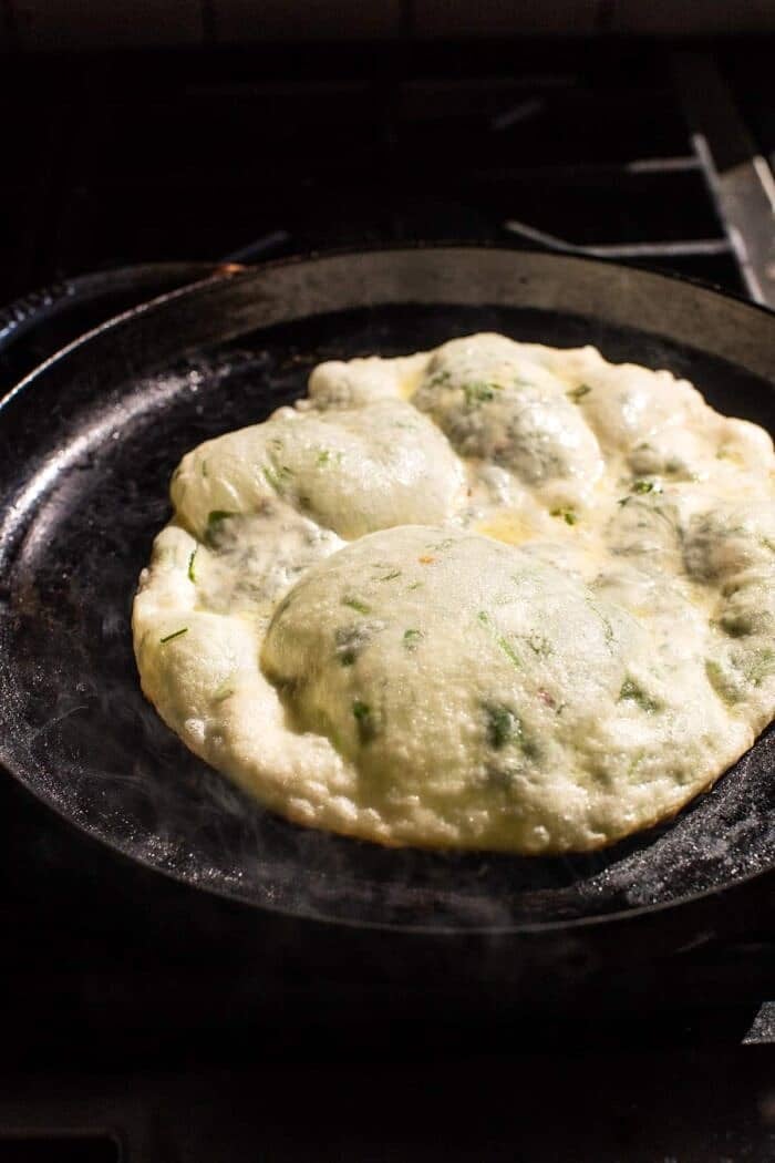Cheesy Herb Stuffed Naan | halfbakedharvest.com prep photo of Cheesy Herb Stuffed Naan cooking on skillet