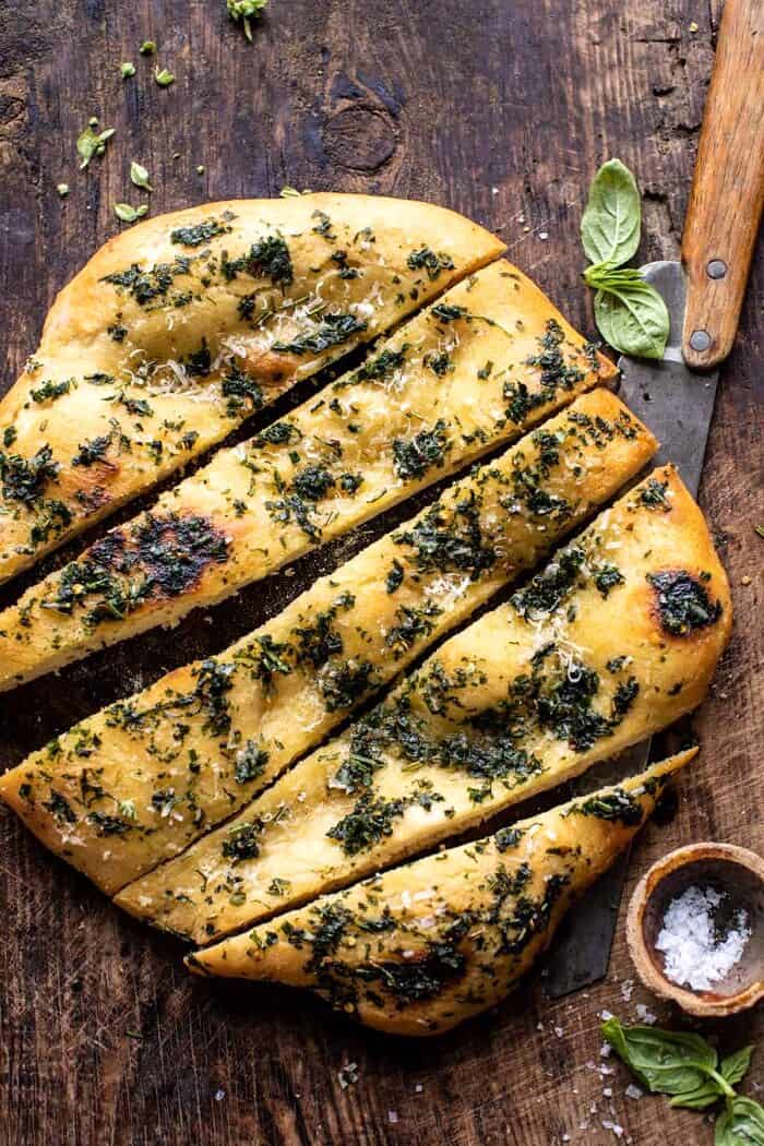 No Knead Rosemary Garlic Parmesan Bread | halfbakedharvest.com overhead photo of No Knead Rosemary Garlic Parmesan Bread with bread slices cut
