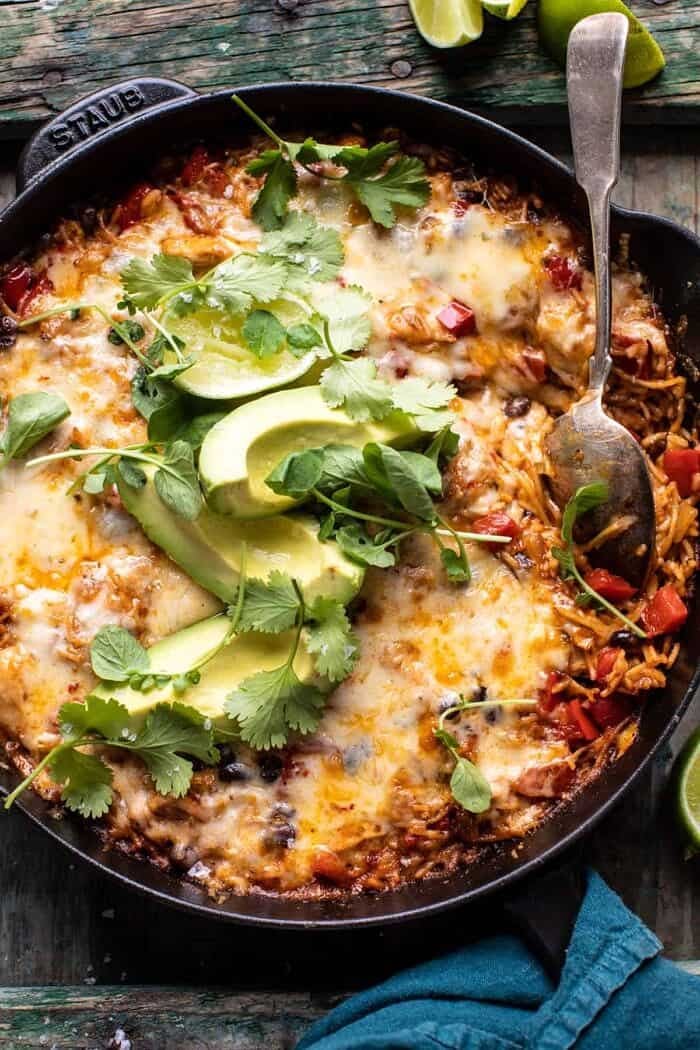 One Skillet Cheesy Cuban Chicken Rice Bake | halfbakedharvest.com overhead close up photo of One Skillet Cheesy Cuban Chicken Rice Bake with spoon in skillet