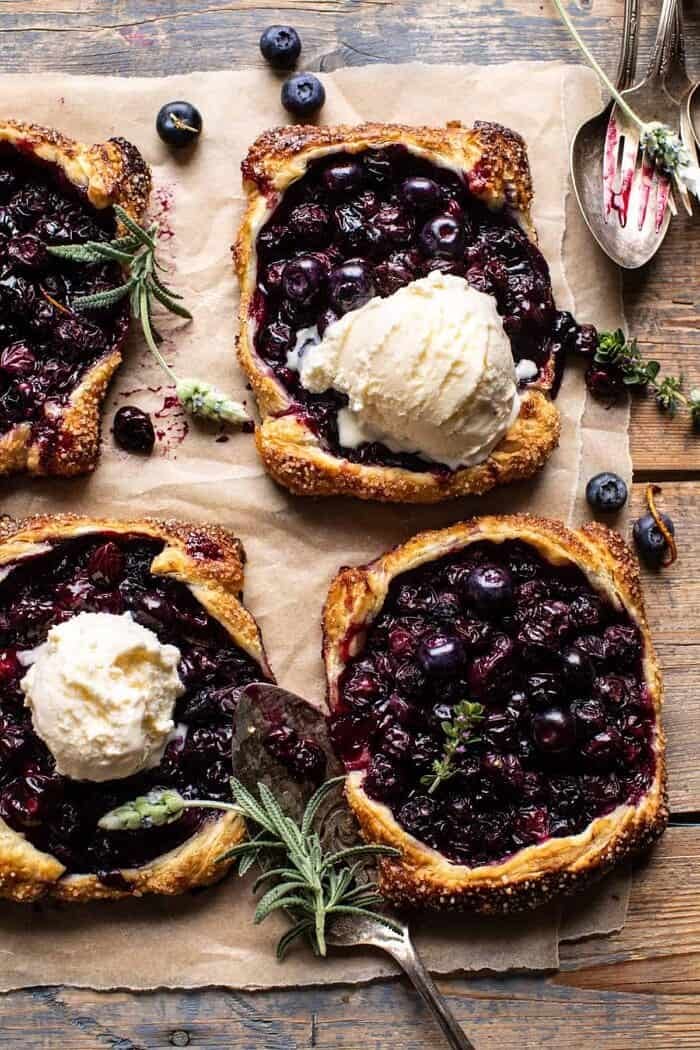 Bursting Blueberry Lemon Thyme Tarts | halfbakedharvest.com overhead photo of Bursting Blueberry Lemon Thyme Tarts with ice cream on top