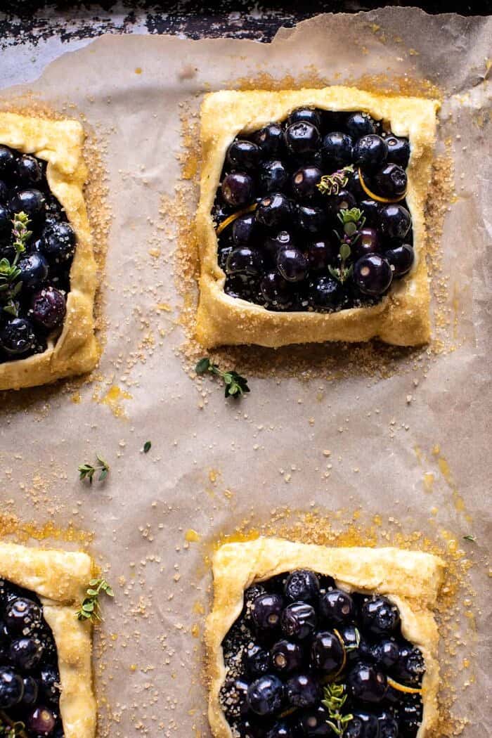 Bursting Blueberry Lemon Thyme Tarts | halfbakedharvest.com overhead prep photo of Bursting Blueberry Lemon Thyme Tarts on baking sheet before baking