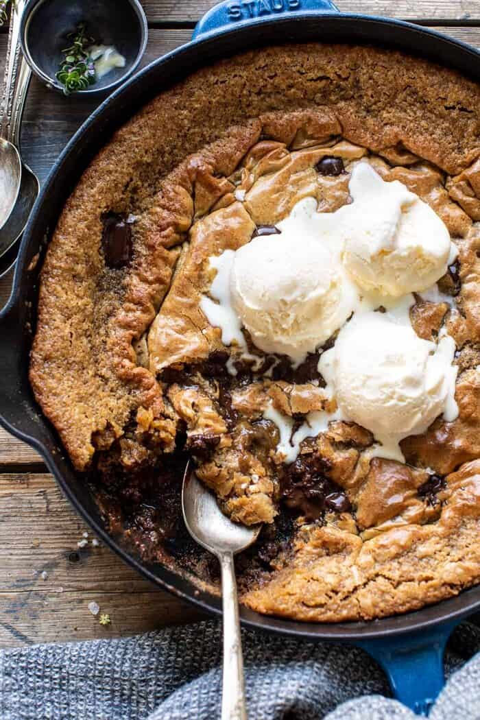 overhead close up photo of Crinkle Top Chocolate Peanut Butter Skillet Blondies with ice cream on top and spoon in skillet 
