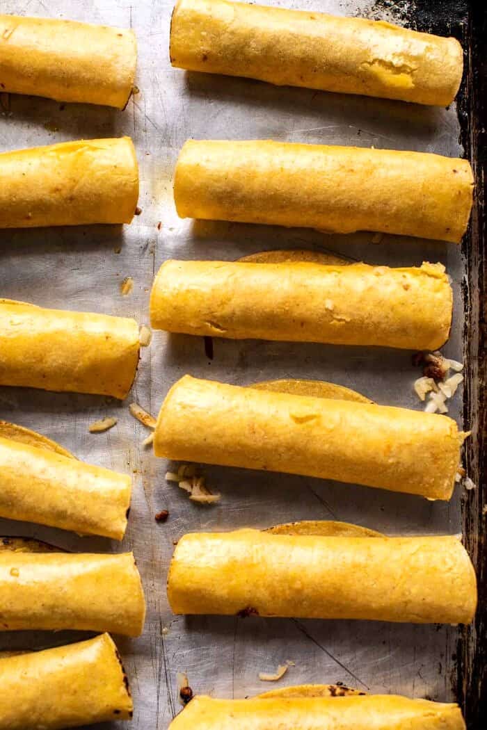 Crispy Chicken Tinga Taquitos with Salty Lime Avocado Crema | halfbakedharvest.com overhead prep photo of Chicken Tinga Taquitos before baking