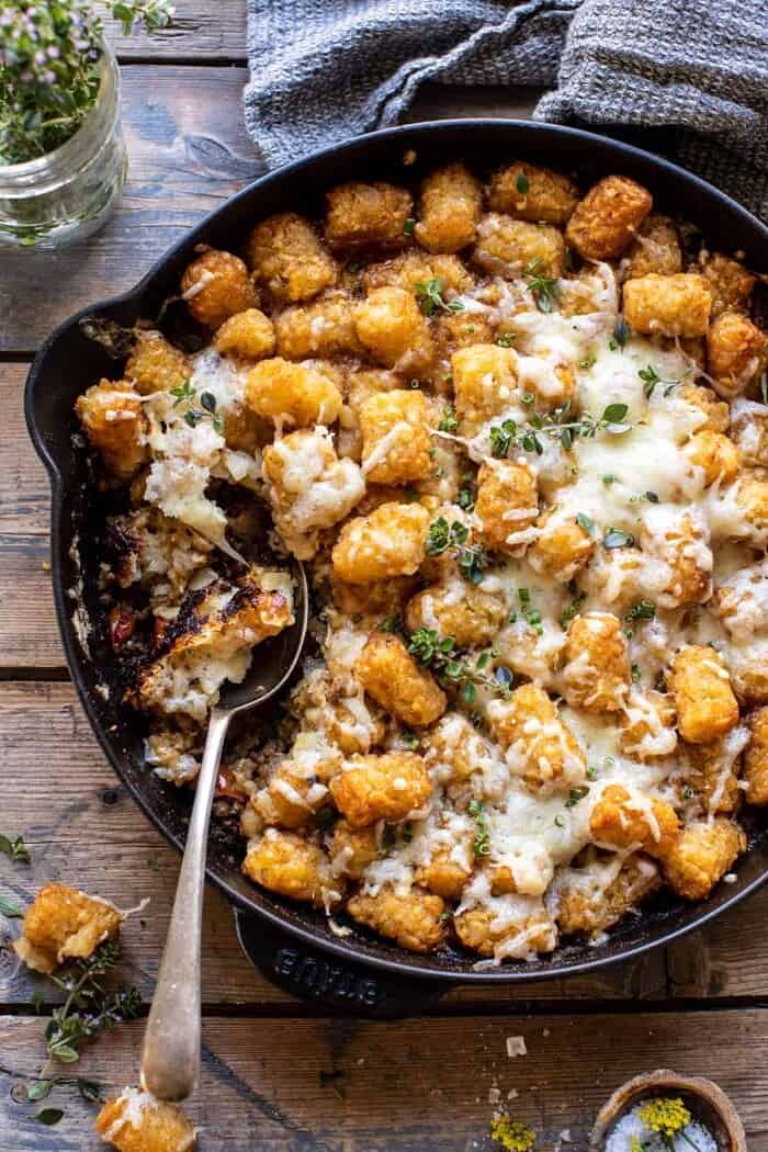 overhead photo of One Skillet French Onion Tater Tot Casserole with spoon in skillet 
