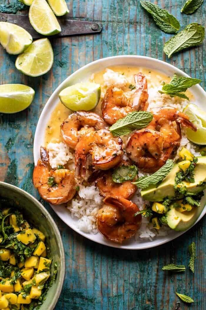 20 Minute Honey Garlic Butter Shrimp | halfbakedharvest.com overhead photo of 20 Minute Honey Garlic Butter Shrimp on plate with rice and mangos