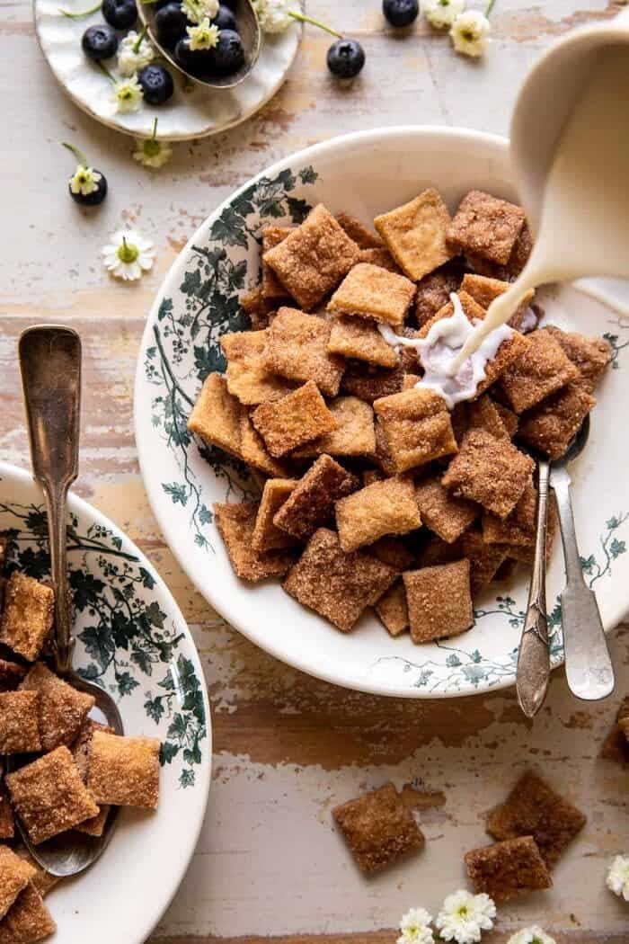 overhead photo of Homemade Cinnamon Toast Crunch cereal in bowl with milk being poured over cereal