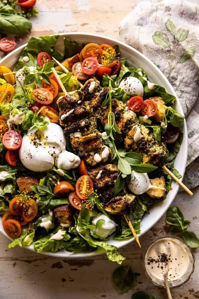 overhead close up photo of Pesto Chicken Caesar Salad with Tomatoes and Burrata