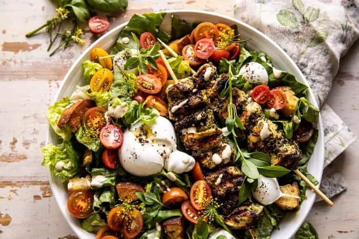 overhead horizontal photo of Pesto Chicken Caesar Salad with Tomatoes and Burrata