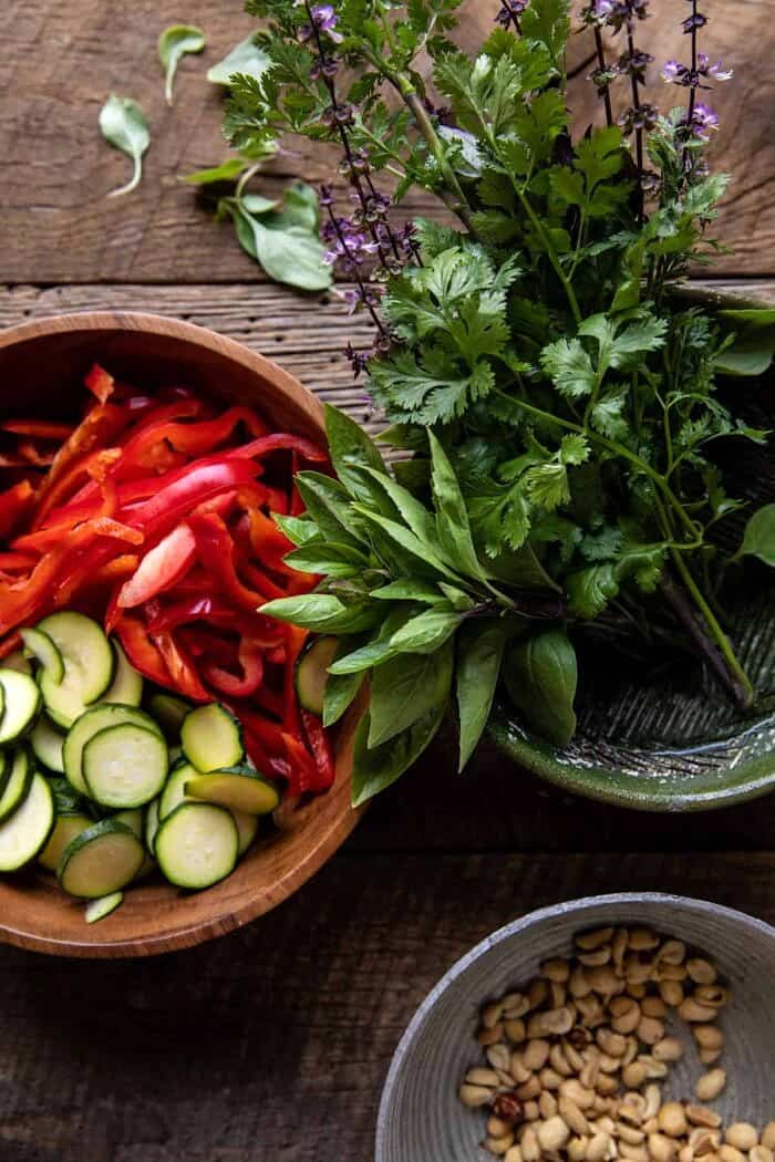 overhead prep photo of raw vegetables, herbs, and peanuts 