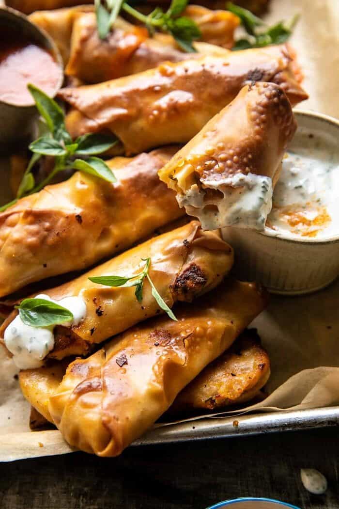 Baked Buffalo Chicken Egg Rolls with Cilantro Lime Ranch | halfbakedharvest.com side angle photo of Baked Buffalo Chicken Egg Roll with Cilantro Lime Ranch