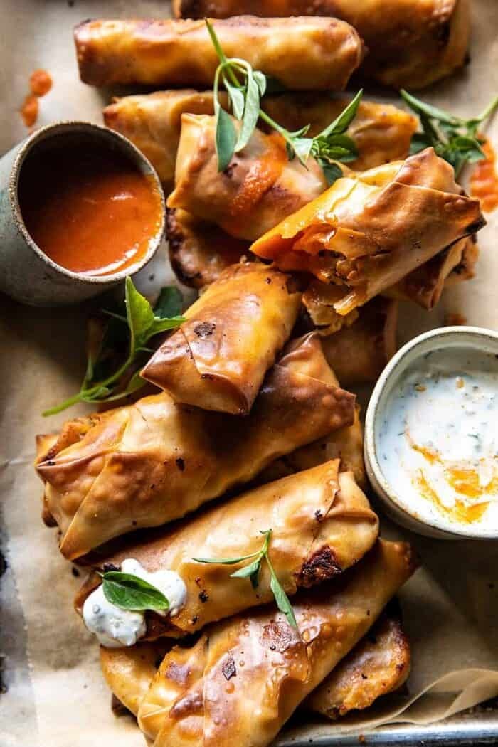 Baked Buffalo Chicken Egg Rolls with Cilantro Lime Ranch | halfbakedharvest.com side photo of Baked Buffalo Chicken Egg Roll broken in half