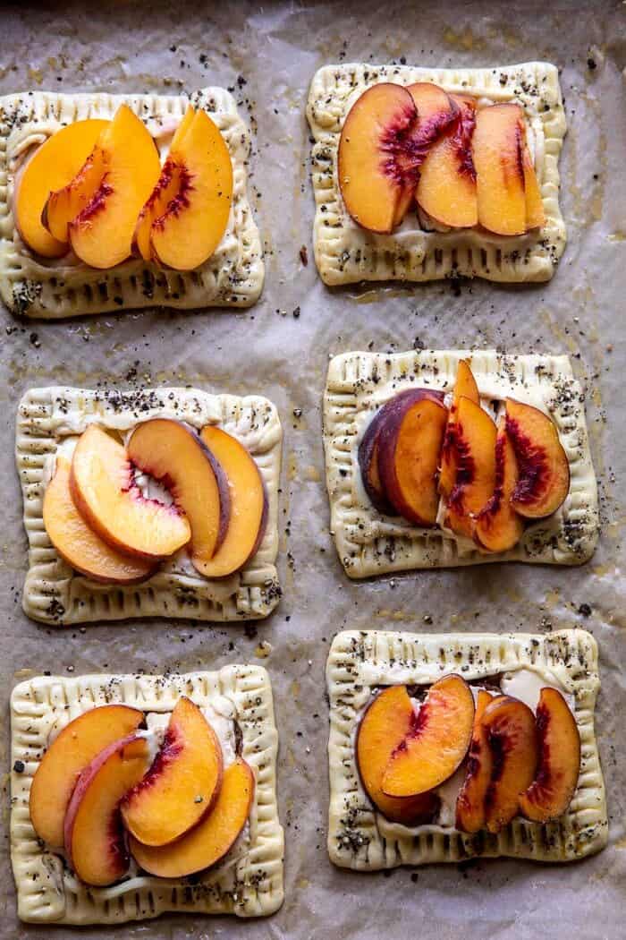 Peach Brie Pastry Tarts with Peppered Rosemary Honey | halfbakedharvest.com overhead photo of Peach Brie Pastry Tarts on baking sheet before baking