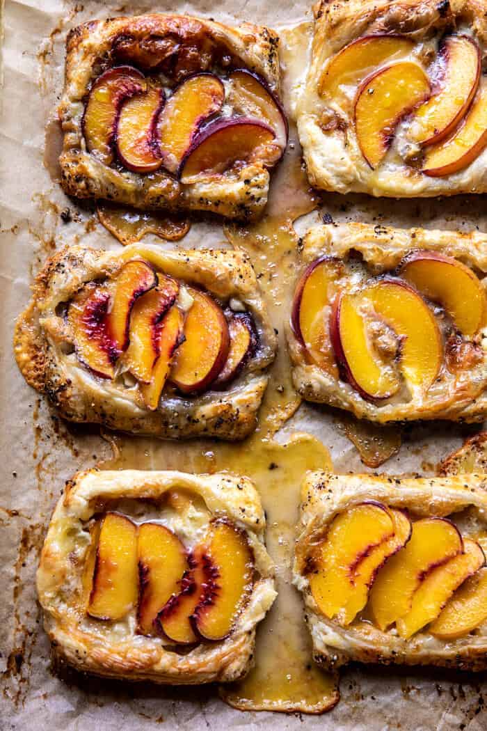 Peach Brie Pastry Tarts with Peppered Rosemary Honey | halfbakedharvest.com overhead photo of Peach Brie Pastry Tarts on baking sheet after baking