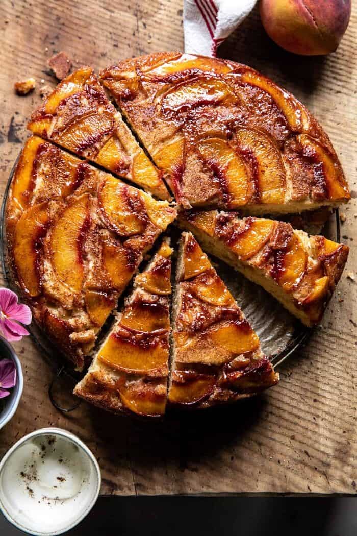 Skillet Cinnamon Sugar Peach Upside Down Cake | halfbakedharvest.com overhead photo of Skillet Cinnamon Sugar Peach Upside Down Cake with slices of cake cut