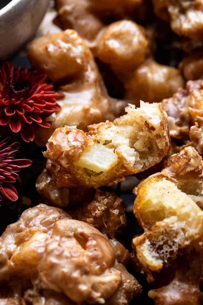 Cinnamon Spiced Apple Fritters with Vanilla Coffee Glaze | halfbakedharvest.com side angled photo of Cinnamon Spiced Apple Fritters with Vanilla Coffee Glaze broken in half