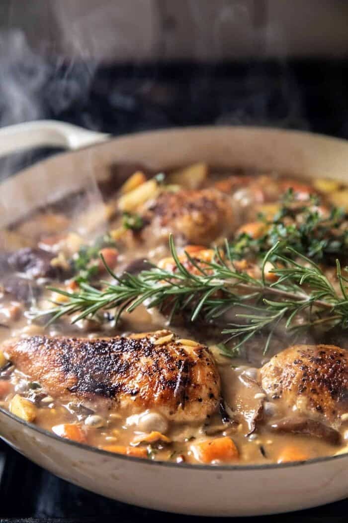 One Pot Lemon Rosemary Dijon Chicken and Butter Toasted Rice Pilaf | halfbakedharvest.com prep photo of chicken and rice cooking in skillet