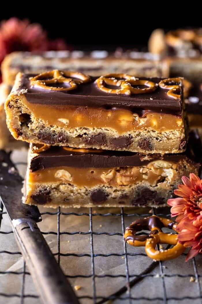 Salted Pretzel Chocolate Chip Cookie Snickers Bars | halfbakehavrest.com side angled photo of Salted Pretzel Chocolate Chip Cookie Snickers Bars
