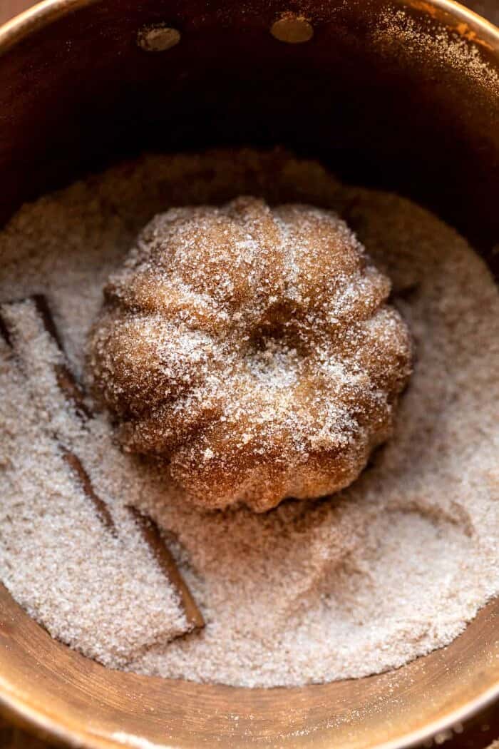 prep photo of Mini Apple Cider Cakes being tossed in cinnamon sugar
