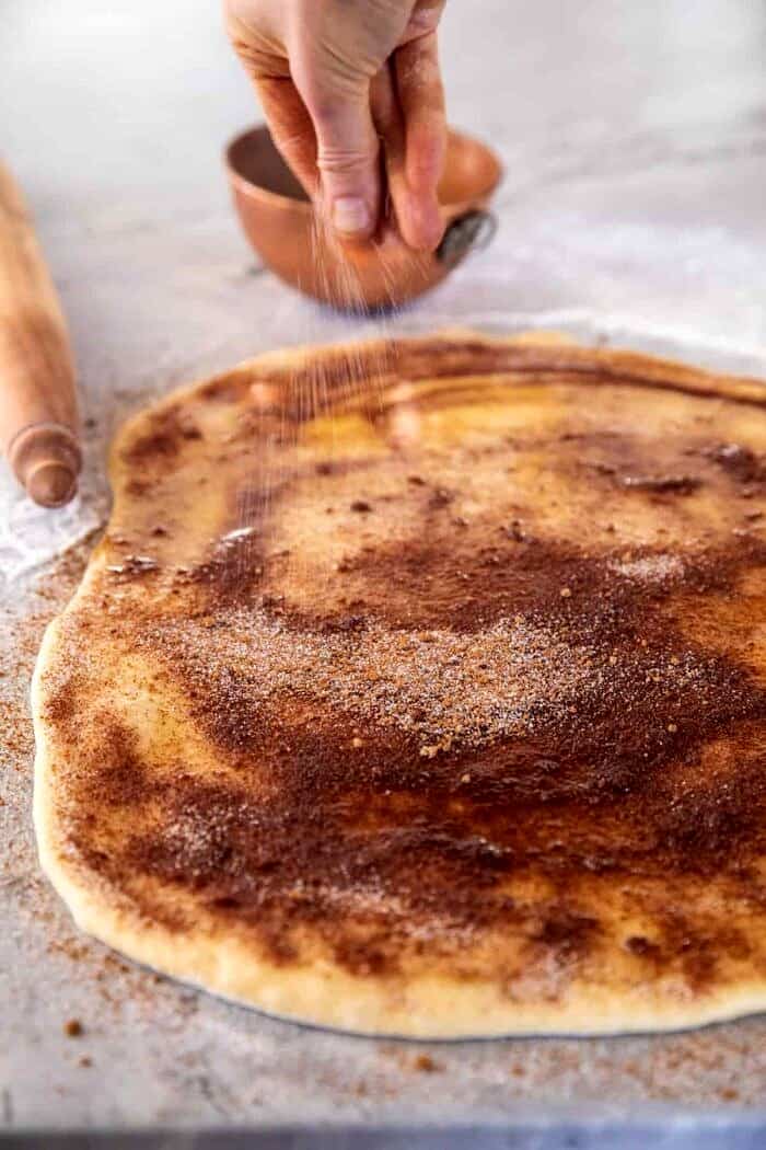 Easy Fluffy Eggnog Cinnamon Rolls | halfbakedharvest.com prep photo of rolling the rolls