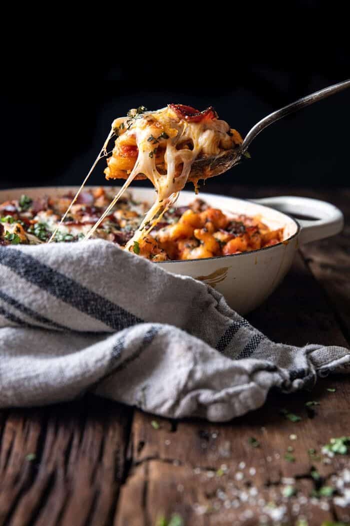 One Pot Spicy Alla Vodka Pizza Pasta | halfbakedharvest.com side angle photo of cheese being pulled out of pan