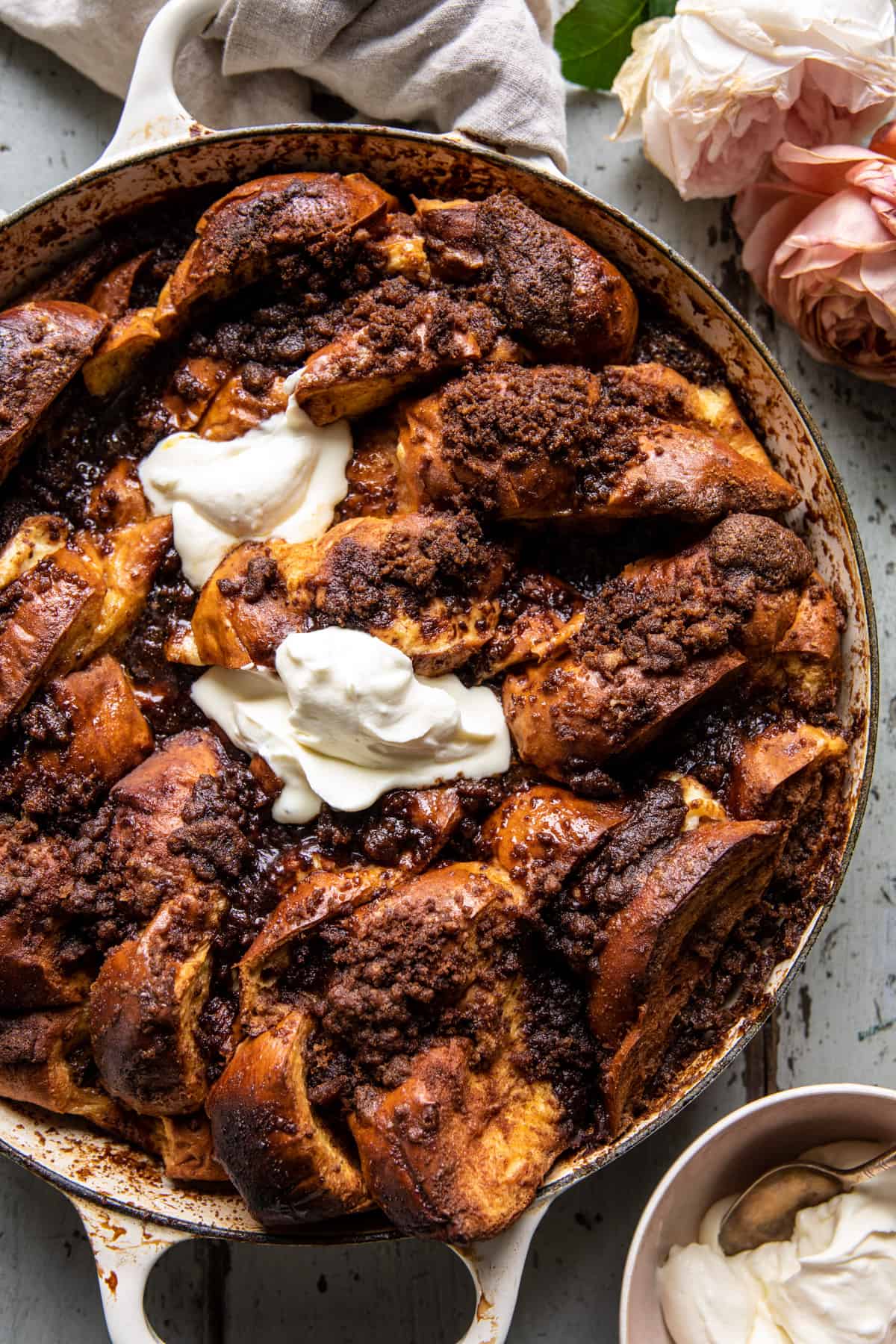 overhead photo of french toast in skillet with cream and flowers