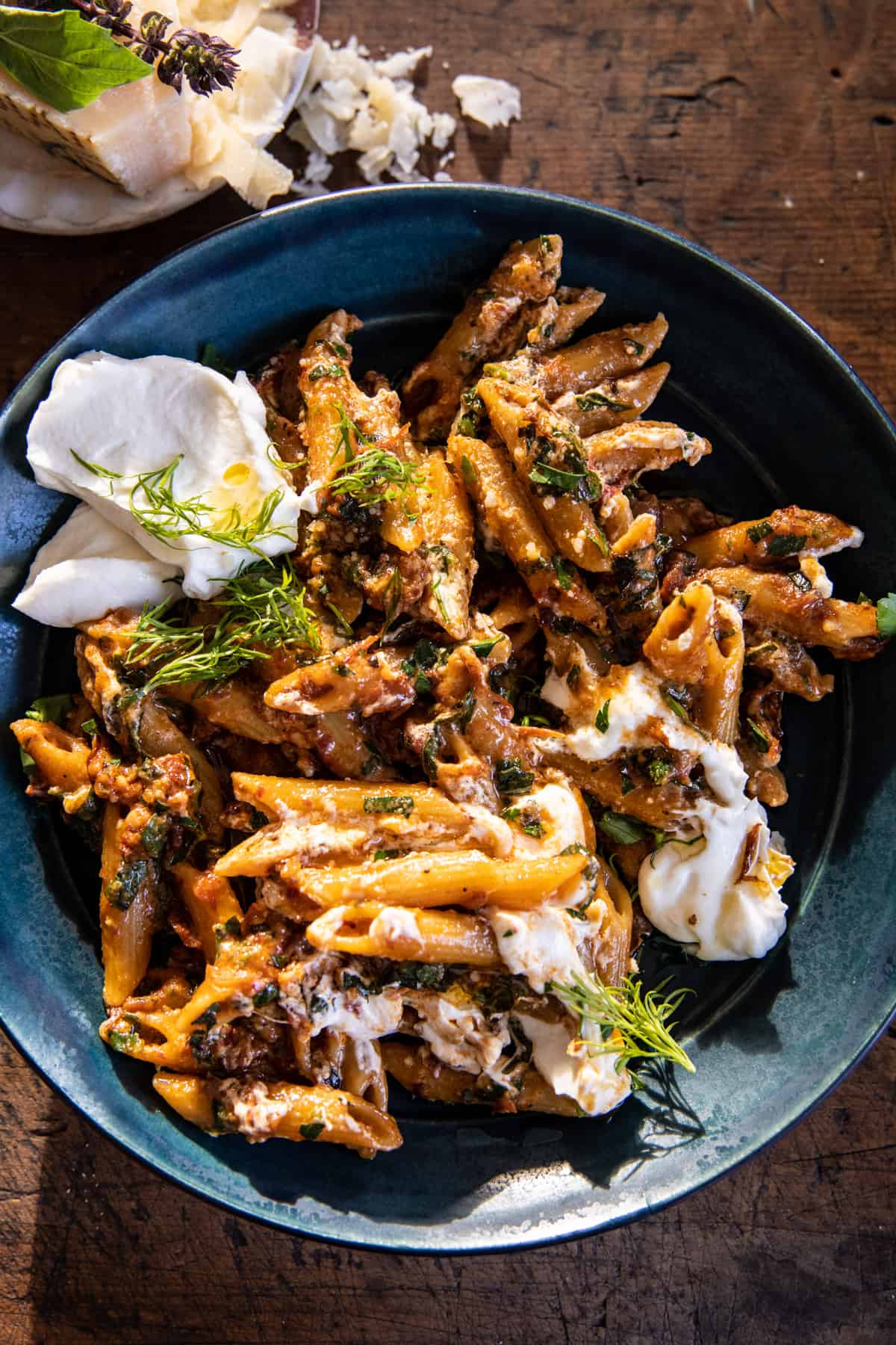 pasta in blue bowl with parmesan on table 