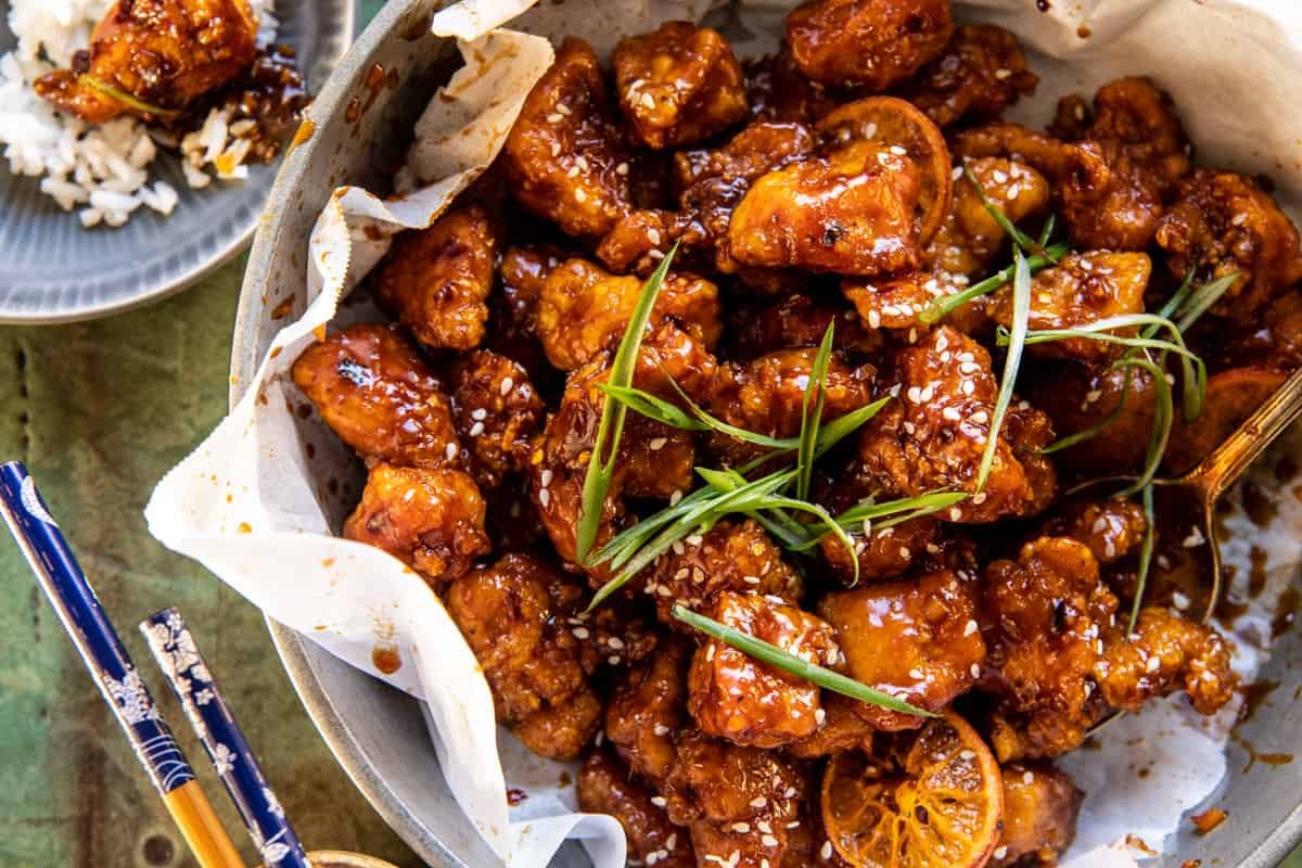 horizontal photo of orange chicken with rice on a side plate