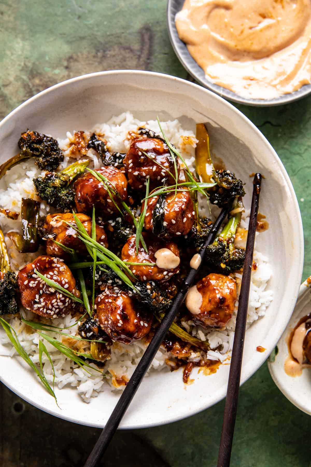 overhead photo of meatballs in bowl with rice and chopsticks