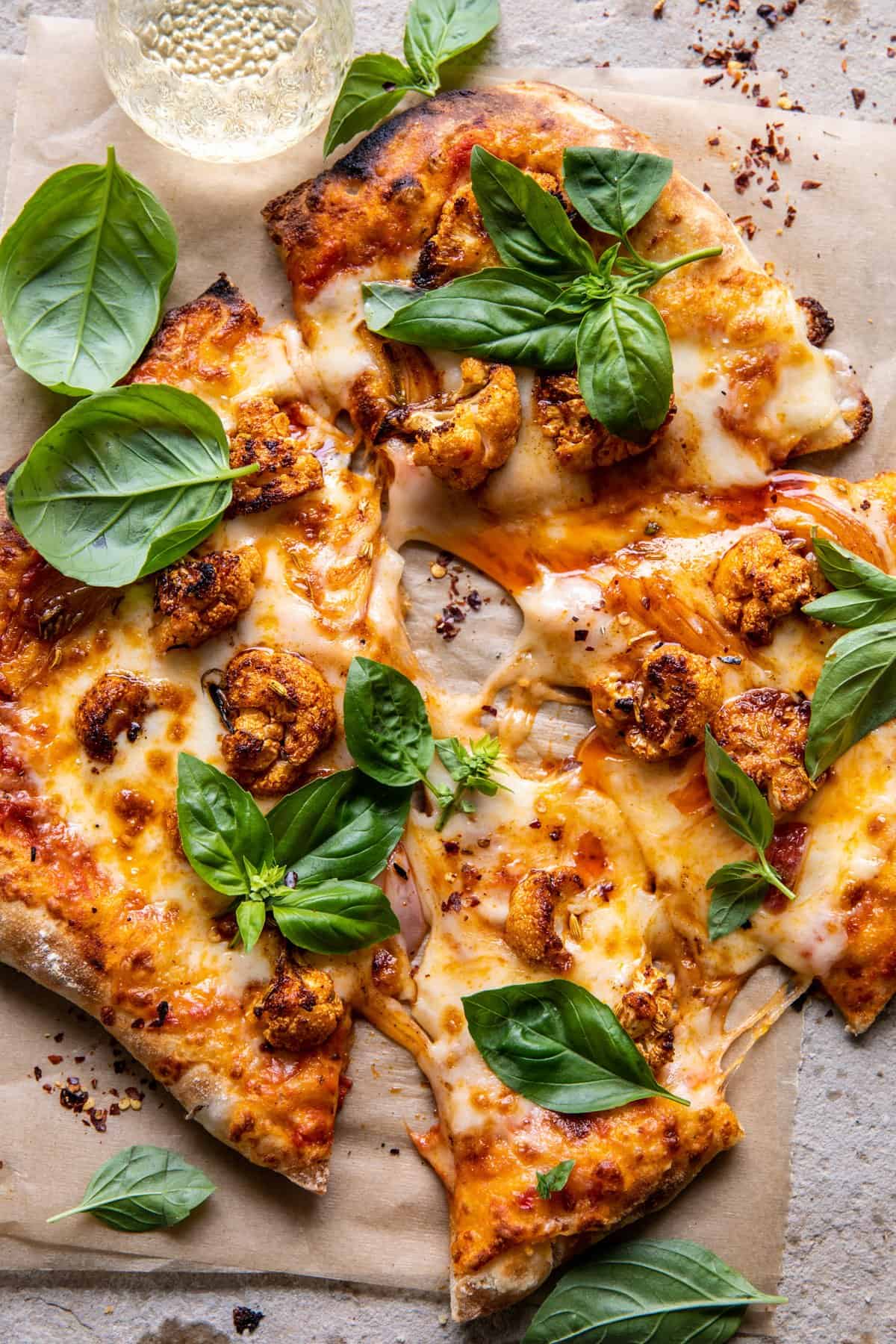 Cauliflower Pepperoni Cheese Pizza with large slices cute from pizza and wine in glas